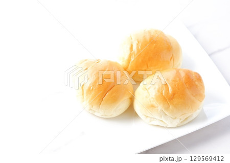 バターロール - 焼きたてで熱々のバターロールが用意された朝食のテーブル バターロール - 焼きたてで熱々のバターロールが用意された朝食のテーブル 129569412