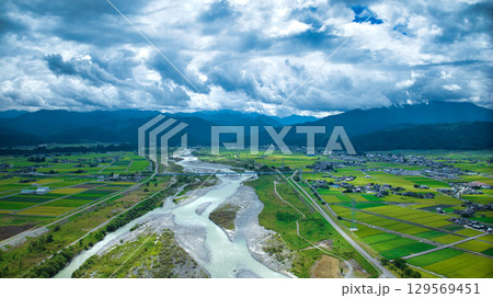 夏の黒部川扇状地の黒部川や北陸新幹線高架橋や北陸自動車道や一般道路などの様子 129569451