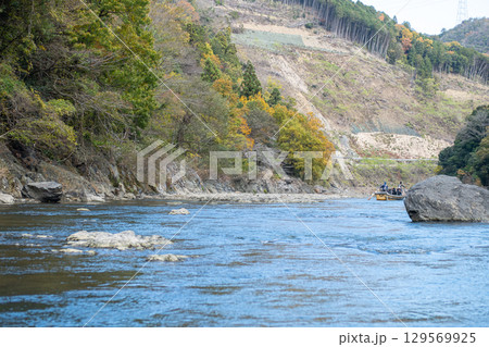 Serene river flowing through vibrant autumn landscape at Hozugawa River 129569925