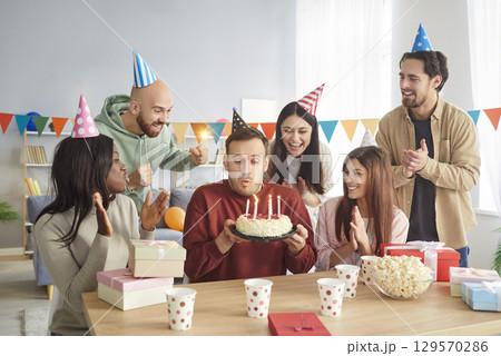 Man Blowing Candles On Birthday Cake At Home Man Blowing Candles On Birthday Cake At Home 129570286