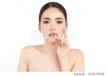 A beautiful young Asian woman with clean, fresh skin against a white background. Skincare, facial treatment, cosmetology, beauty, and spa. An elegant portrait of an Asian woman. A beautiful young Asian woman with clean, fresh skin against a white background. Skincare, facial treatment, cosmetology, beauty, and spa. An elegant portrait of an Asian woman. 129570526