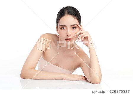 A beautiful young Asian woman with clean, fresh skin against a white background. Skincare, facial treatment, cosmetology, beauty, and spa. An elegant portrait of an Asian woman. 129570527