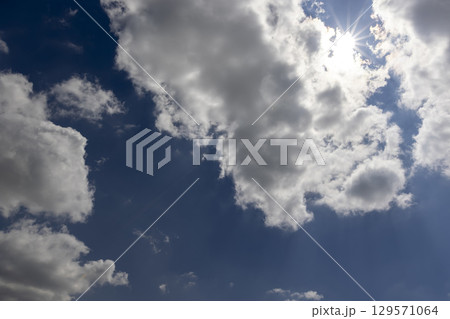 beautiful blue sky with lush white clouds in sunny bright weather 129571064