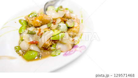 Stir-Fried Twisted Cluster Bean, Thai food on a white plate. Stir-Fried Twisted Cluster Bean, Thai food on a white plate. 129571468