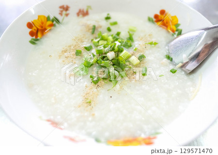 Bowl of rice porridge with green onions 129571470