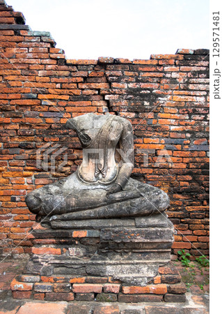 Wat Chaiwatthanaram temple, Ayutthaya historical park, Ayutthaya, Thailand Ancient Buddha statue near brick wall ruins Wat Chaiwatthanaram temple, Ayutthaya historical park, Ayutthaya, Thailand Ancient Buddha statue near brick wall ruins 129571481