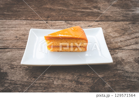 Slice of Thai tea cake on a white plate 129571564
