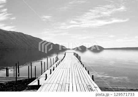 「7月の支笏湖」湖面に伸びる「桟橋」穏やかな水面と空「白黒」 129571733