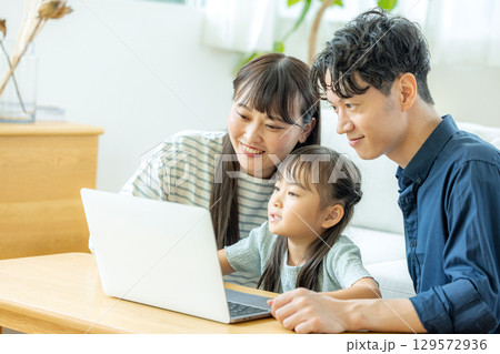 パソコンを見る家族 129572936