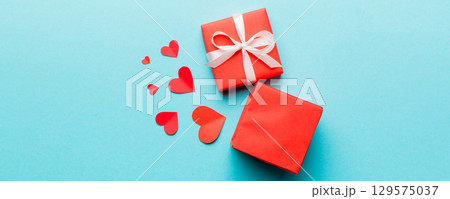 Happy valentines day opened heart shape gift box with small hearts, on colored background, valentines day card - top view concept Happy valentines day opened heart shape gift box with small hearts, on colored background, valentines day card - top view concept 129575037