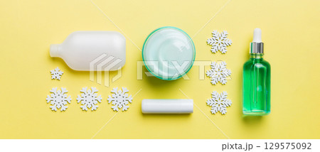 Makeup products and Christmas decorations on color background. Top view New year Beauty concept Makeup products and Christmas decorations on color background. Top view New year Beauty concept 129575092