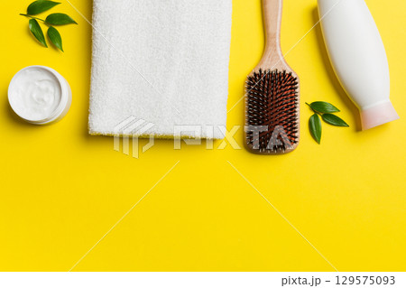 cosmetic for hair care, cream and towel on a colored background top view. flat lay cosmetic for hair care, cream and towel on a colored background top view. flat lay 129575093