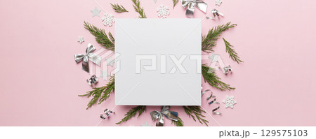 Flat lay Christmas composition. square Paper blank, pine tree branches, christmas decorations on Colored background. Top view, copy space for text Flat lay Christmas composition. square Paper blank, pine tree branches, christmas decorations on Colored background. Top view, copy space for text 129575103