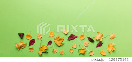 Autumn composition. Pattern made of dried leaves and other design accessories on table. Flat lay, top view Autumn composition. Pattern made of dried leaves and other design accessories on table. Flat lay, top view 129575142