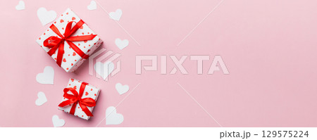 Valentine day composition: red gift box with bow and heart. Christmas present. View from above. Space for text. Holday greeting card 129575224
