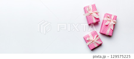 Valentine day composition: red gift box with bow and heart. Christmas present. View from above. Space for text. Holday greeting card 129575225