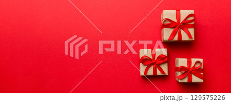 Valentine day composition: red gift box with bow and heart. Christmas present. View from above. Space for text. Holday greeting card 129575226