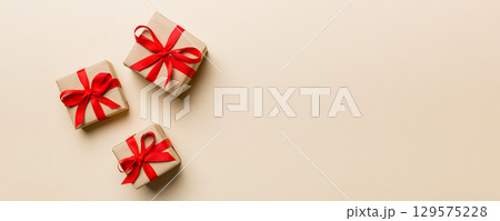 Valentine day composition: red gift box with bow and heart. Christmas present. View from above. Space for text. Holday greeting card 129575228