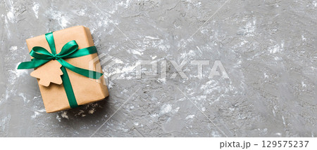 wrapped christmas or other holiday handmade present in paper with colored ribbon. Present box, decoration of gift on colourfull table, top view with copy space wrapped christmas or other holiday handmade present in paper with colored ribbon. Present box, decoration of gift on colourfull table, top view with copy space 129575237