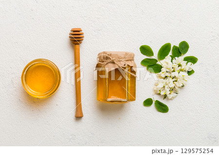 honey jar with acacia flowers and leaves. fresh honey top view flat lay honey jar with acacia flowers and leaves. fresh honey top view flat lay 129575254