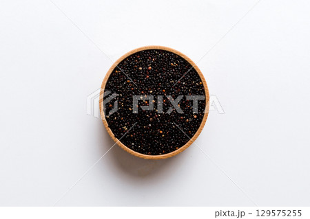 quinoa seeds in bowl on colored background. Healthy kinwa in small bowl. Healthy superfood quinoa seeds in bowl on colored background. Healthy kinwa in small bowl. Healthy superfood 129575255