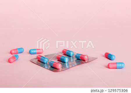 Medicine pills on a light background. Medicines and prescription pills flat lay background. Blue and pink medical tablets in blister 129575306