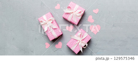 Valentine day composition Background: red gift box with bow and heart. Christmas present. View from above. Holday greeting card Valentine day composition Background: red gift box with bow and heart. Christmas present. View from above. Holday greeting card 129575346