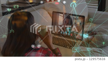 Image of network of connections with icons over caucasian woman having laptop image call Image of network of connections with icons over caucasian woman having laptop image call 129575616