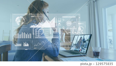 Image of digital screens with data over caucasian woman having image call on laptop 129575835