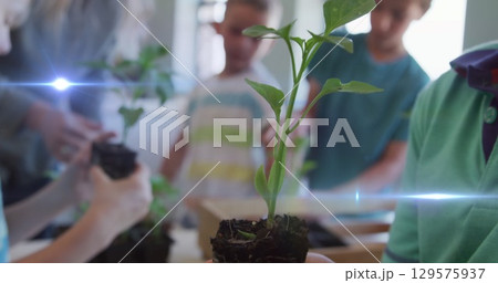 Image of light trails over diverse schoolchildren and teacher holding plants Image of light trails over diverse schoolchildren and teacher holding plants 129575937