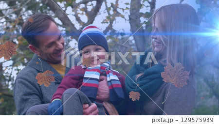 Image of light trails and leaves falling over caucasian family Image of light trails and leaves falling over caucasian family 129575939