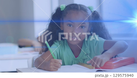 Image of light trails over african american schoolgirl 129575940