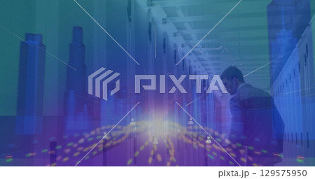 Image of light trails over 3d cityscape model over male engineer walking in server room 129575950