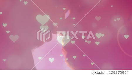 Image of glowing spots and hearts over diverse couple embracing Image of glowing spots and hearts over diverse couple embracing 129575994