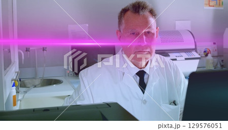 Image of light spots over caucasian male doctor in lab 129576051