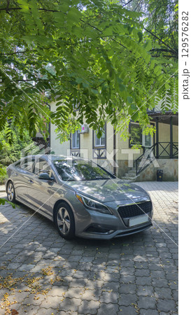 Car parked near the house. Tourist recreation. Park area. Summer nature. Vehicle 129576282