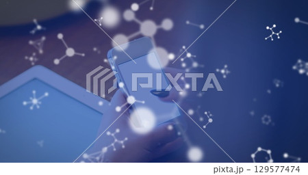 Image of molecules over hands of caucasian woman using smartphone 129577474