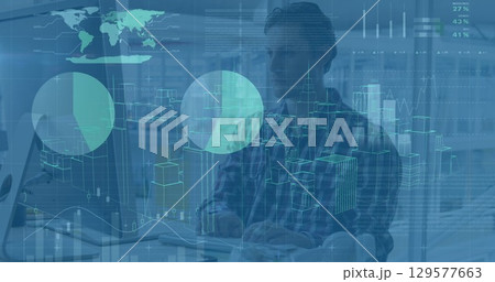 Image of cityscape model and graphs over focused caucasian architect using desktop computer 129577663