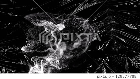 Image grey ring of smoke over light on moving shiny black plastic 129577789