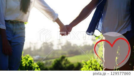 Image of heart icon over caucasian couple in love holding hands in park 129577860