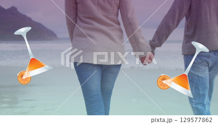 Image of cocktail glasses falling over caucasian couple in love holding hands by seaside 129577862