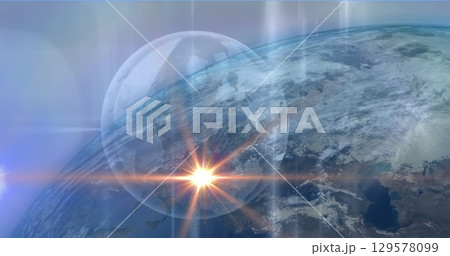 Image of light spot over globe against blue background 129578099