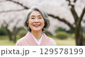 桜の中を歩く着物の女性 129578199