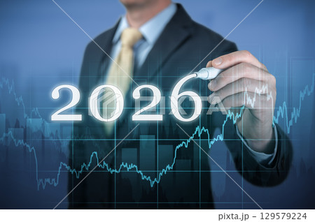 Businessman drawing growing virtual hologram of statistics, graph and chart for new year 2026 business growth and financial planning concept 129579224