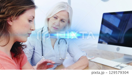 Digital composite image of blue light moving over caucasian doctor comforting patient at hospital 129579304