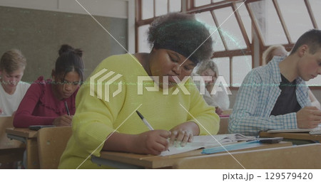 Image of globe and graph over class of diverse pupils learning Image of globe and graph over class of diverse pupils learning 129579420