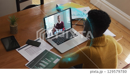 Image of spinning globe over african american woman having a image call on laptop at home 129579780