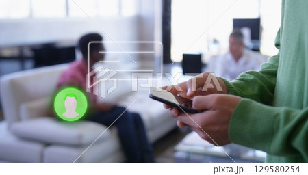 Image of midsection of man using cellphone with message and profile icon in office 129580254