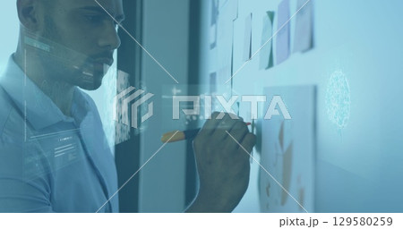 Image of infographic interface, dna helix over african american man writing on board in office Image of infographic interface, dna helix over african american man writing on board in office 129580259