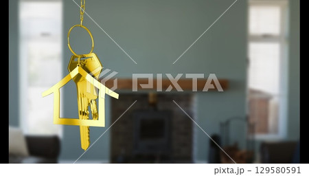 Image of key with keychain in shape of house over living room interior Image of key with keychain in shape of house over living room interior 129580591